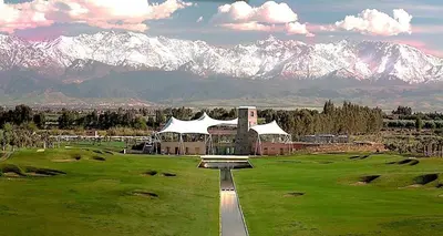 a building on a golf course with mountains in the background at Noria Golf Marrakech in Marrakech