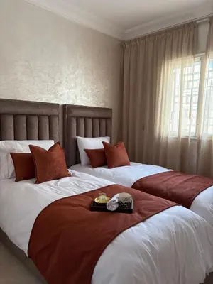 two beds in a hotel room with a tray of food at Charmant appartement familial in Marrakech