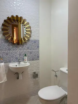 a bathroom with a toilet and a sink and a mirror at Charmant appartement familial in Marrakech