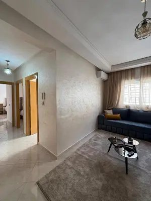 a living room with a couch and a table at Charmant appartement familial in Marrakech