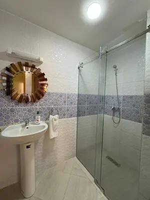 a bathroom with a sink and a glass shower at Charmant appartement familial in Marrakech