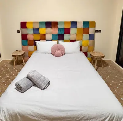 a bed with two pillows and a colorful headboard at Appartement Miramas 2 E2 in Marrakech