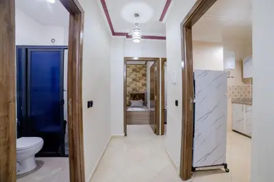 a bathroom with a toilet and a hallway with a fireplace at Charming and quiet apartment 2 in Marrakech