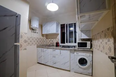 a white kitchen with a washing machine in it at Charming and quiet apartment 2 in Marrakech