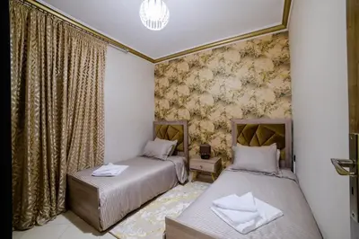 two beds in a room with a wall mural at Charming and quiet apartment 2 in Marrakech