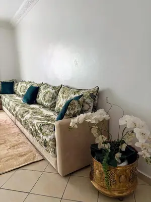 a living room with a couch and a vase with flowers at Appartement cosy in Marrakech