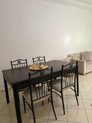 a black dining table and chairs in a living room at Appartement cosy in Marrakech