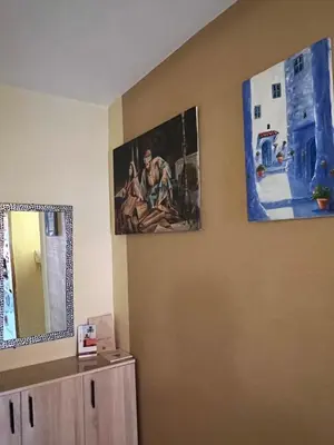 a room with two pictures on the wall and a mirror at Marrakesh cozy apartment 15mn city center in Marrakech