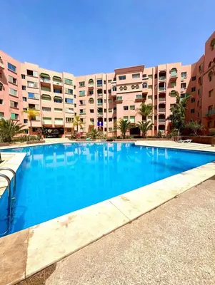 a large swimming pool in front of a building at Confort et style en pleins centre de Hivernage in Marrakech