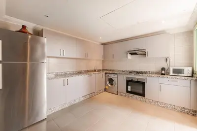 a kitchen with white cabinets and a stainless steel refrigerator at Confort et style en pleins centre de Hivernage in Marrakech