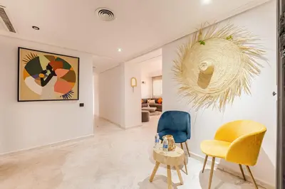 a living room with a yellow chair and a table at Confort et style en pleins centre de Hivernage in Marrakech