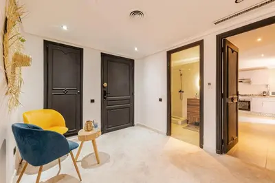 a living room with a blue chair and a table at Confort et style en pleins centre de Hivernage in Marrakech
