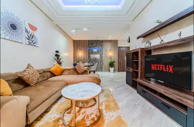 a living room with a couch and a tv at Appartement cosy moderne piscine in Marrakech