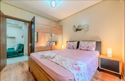 a bedroom with a large bed with pink sheets at Appartement cosy moderne piscine in Marrakech
