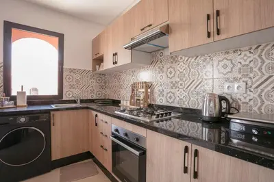 a kitchen with wooden cabinets and a black appliance at The Medina Touch - Marrakech in Marrakech