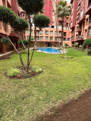 a park with a tree and a building at Chez Houda in Marrakech
