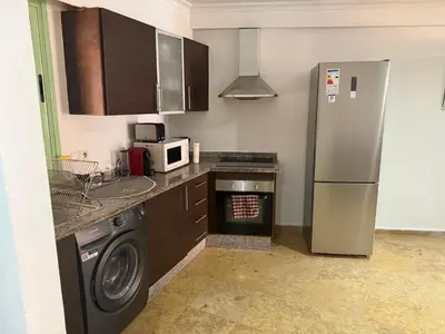 a kitchen with a stainless steel refrigerator and a washer at Chez Houda in Marrakech