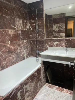 a bathroom with a bath tub and a sink at Chez Houda in Marrakech