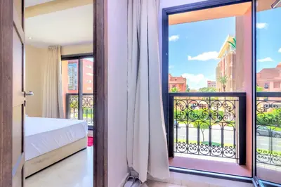 a bedroom with a bed and a balcony at Residence Jnan Atlas gueliz in Marrakech
