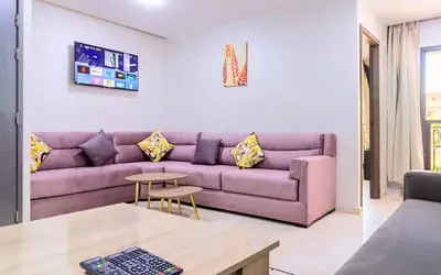 a living room with a purple couch and a table at Residence Jnan Atlas gueliz in Marrakech