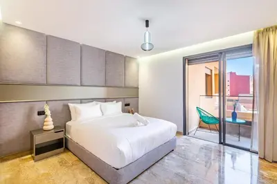 a bedroom with a large white bed and a chair at Stylish modern 1BR in gueliz in Marrakech