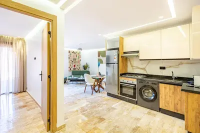 a kitchen and living room with a stove and a table at Stylish modern 1BR in gueliz in Marrakech