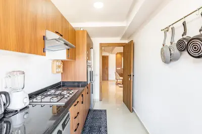 a kitchen with wooden cabinets and a stove top oven at 5 Stars Home with Pool & Parking in Marrakech