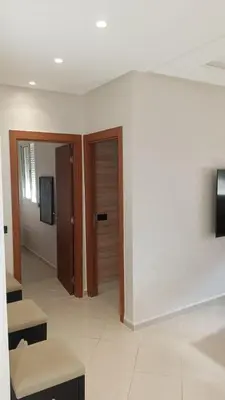 a room with a hallway with a door and benches at appartement moderne marrakech in Marrakech