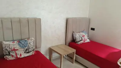 a small room with two beds and a table at appartement moderne marrakech in Marrakech