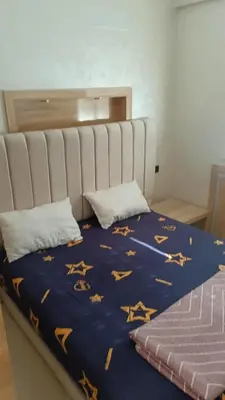 a bed with a blue comforter with stars on it at appartement moderne marrakech in Marrakech