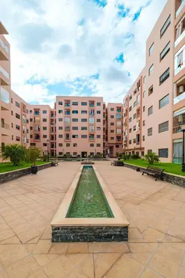 a large courtyard with a fountain in front of a building at Luxe 2-Bedroom with Pool in Marrakech in Marrakech