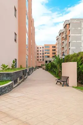a bench in the middle of a walkway with buildings at Luxe 2-Bedroom with Pool in Marrakech in Marrakech