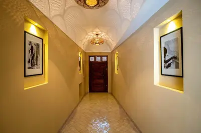 a hallway with a door and pictures on the walls at Riad Malaika in Marrakech