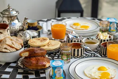 a table topped with breakfast foods and orange juice at Riad Malaika in Marrakech