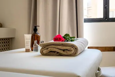 a towel sitting on a bed with a bottle of wine at Riad Malaika in Marrakech