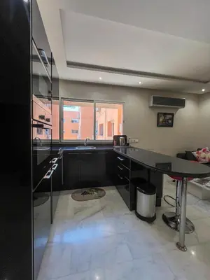 a kitchen with a black counter and a table at Apartment with pool in Guéliz Hadika al koubra in Marrakech