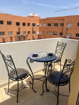 a table and two chairs on a balcony at Apartment with pool in Guéliz Hadika al koubra in Marrakech