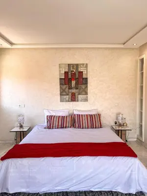 a bedroom with a large white bed with red pillows at Apartment with pool in Guéliz Hadika al koubra in Marrakech