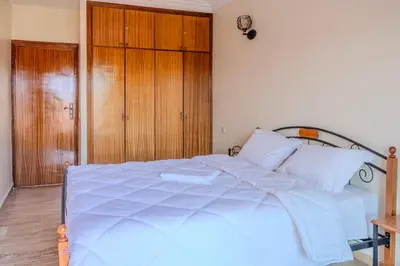 a white bed in a bedroom with a wooden cabinet at Chic & spacious apartment in Gueliz in Marrakech