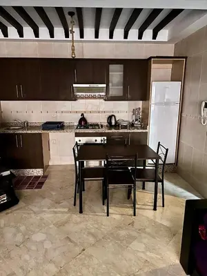 a kitchen with a table and chairs and a refrigerator at Gueliz -La Kasbah AC oneBedroom Apart with parking in Marrakech