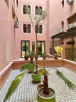 a courtyard with three potted plants and a building at Gueliz -La Kasbah AC oneBedroom Apart with parking in Marrakech