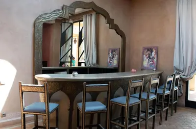a bar with chairs and a mirror in a room at Domaine Marradise in Marrakech