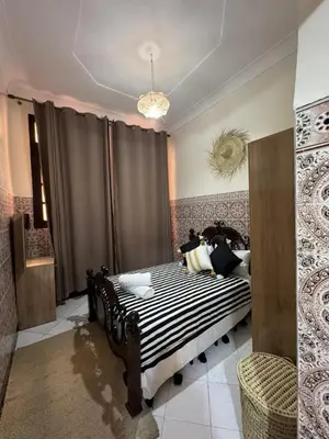 a bedroom with a bed with black and white stripes at Logment cosy in Marrakech
