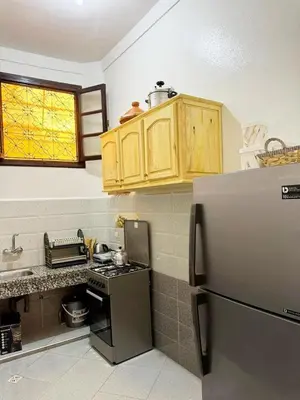 a kitchen with a stove and a refrigerator at Logment cosy in Marrakech