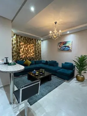 a living room with a blue couch and a table at Appartement moderne dans Marrakech in Marrakech