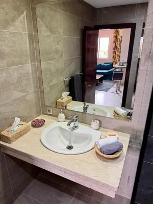 a bathroom counter with a sink and a mirror at Appartement moderne dans Marrakech in Marrakech