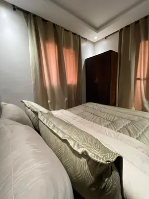 a bedroom with two white beds and a window at Appartement moderne dans Marrakech in Marrakech