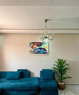 a living room with a blue couch and a painting at Appartement moderne dans Marrakech in Marrakech