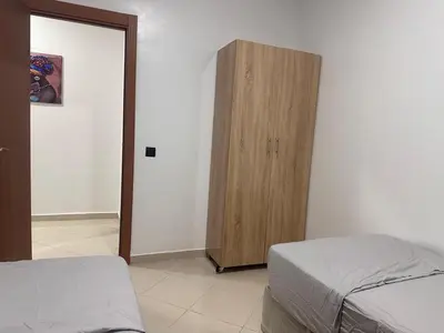 a bedroom with a wooden cabinet next to a bed at Dar al Montazah in Marrakech