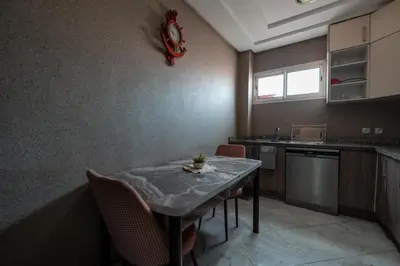 a kitchen with a table and chairs in a room at La maison du soleil in Oulad Akkou
